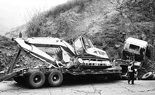 一辆载有挖掘机的大型平板货车拐弯时因车速过